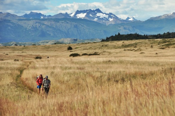 Mike and Emily hiking through the grass.