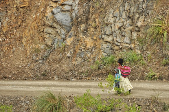 A typically dressed lady walking with her son.